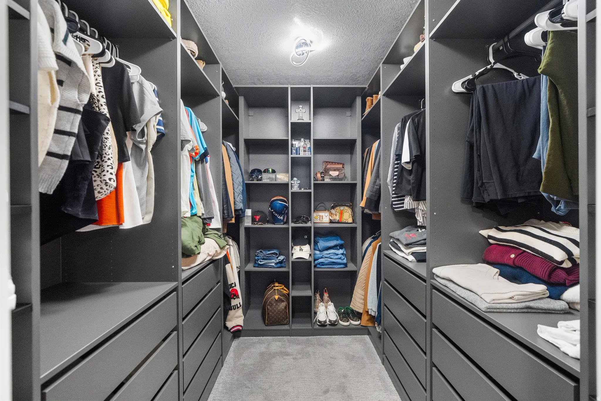 Custom closet system featuring dark grey cabinetry with integrated shelving and drawer storage