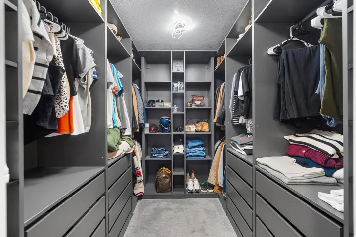 Custom closet system featuring dark grey cabinetry with integrated shelving and drawer storage