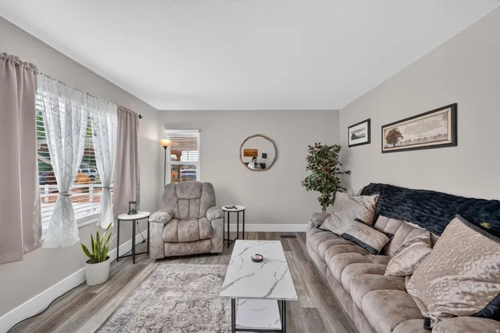 Living area featuring light gray walls, wood-finish flooring, and white baseboards