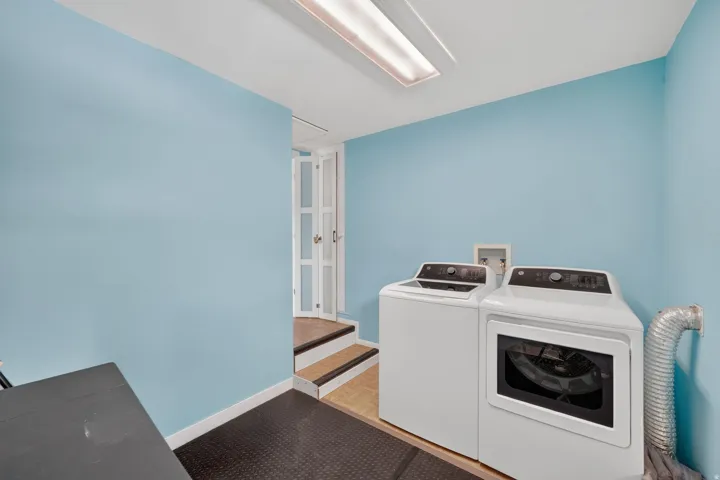 Dedicated laundry area featuring a washer and dryer, finished with a black rubberized floor