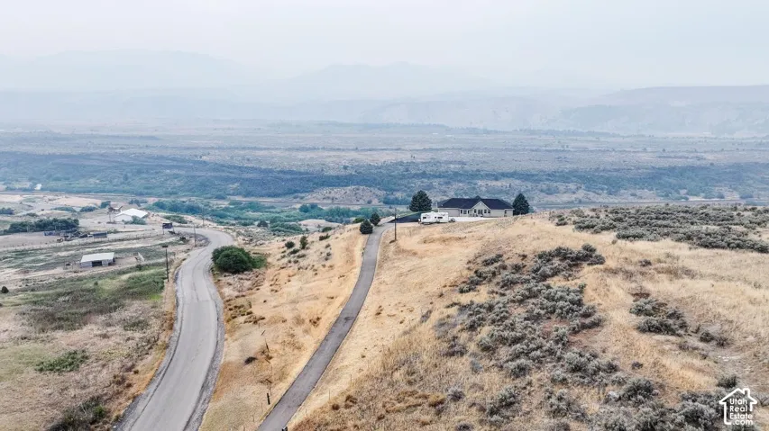 Hilltop residence featuring a long paved driveway and a single-story design