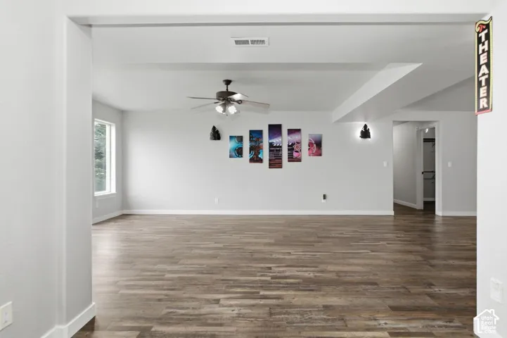Spacious room featuring wood-finish flooring, a ceiling fan, and recessed lighting