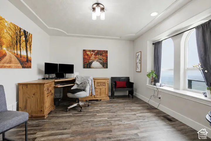 Spacious interior featuring wood-finish flooring, white walls, and a recessed ceiling with a contemporary light fixture