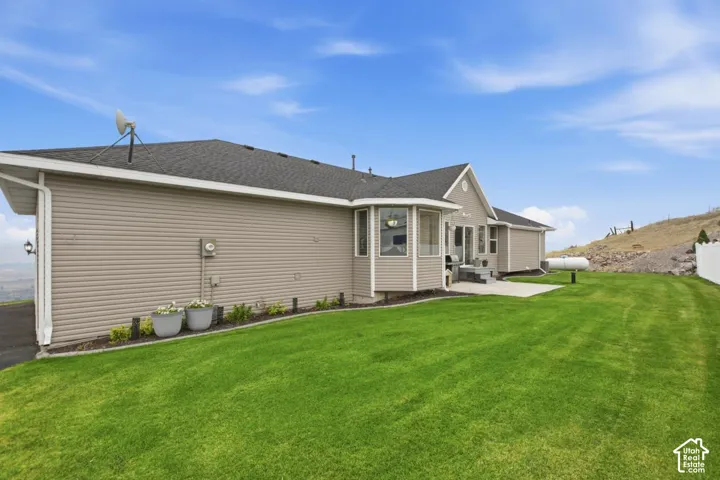 Expansive green lawn bordering the house, featuring a side patio and an octagonal bay window