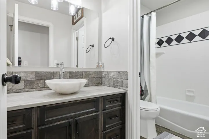 Bathroom featuring a dark wood-finish vanity with a light countertop and a vessel sink