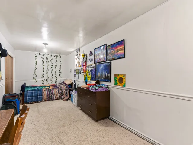 Carpeted room with white walls and chair rail molding