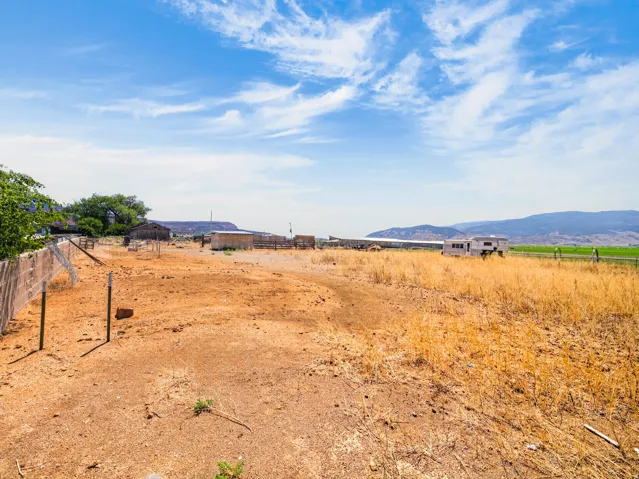 Expansive land parcel featuring a rustic wood fence and distant mountain range