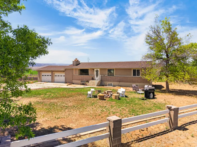 Ranch-style residence featuring a two-car garage, brick accents, and a front porch