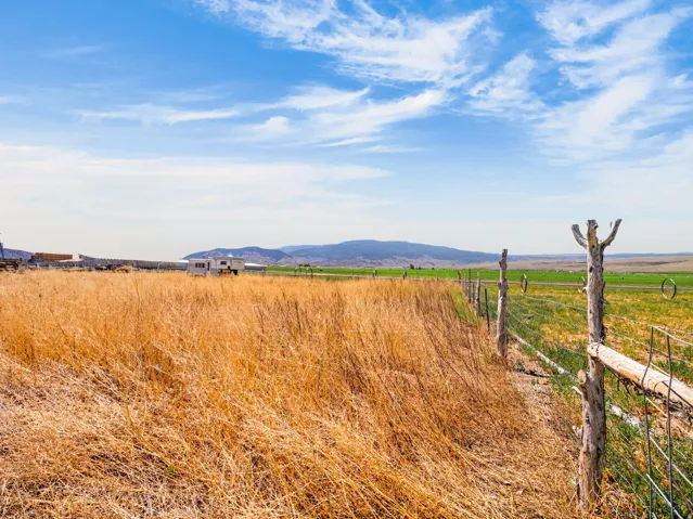 Expansive land parcel featuring natural golden grasses and a rustic wooden fence line