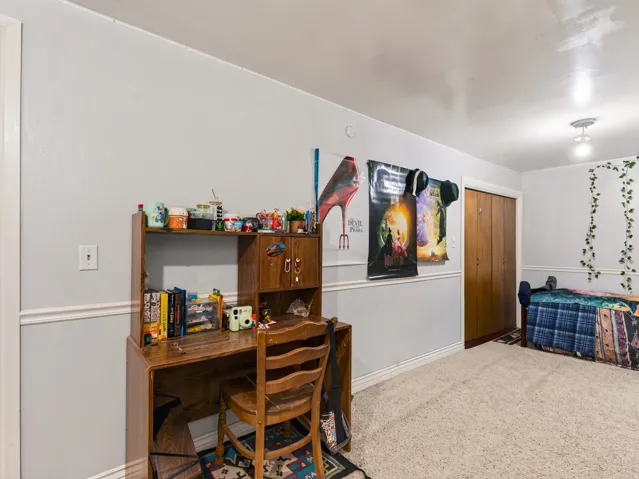 Spacious room featuring light gray walls, white trim, and carpet flooring