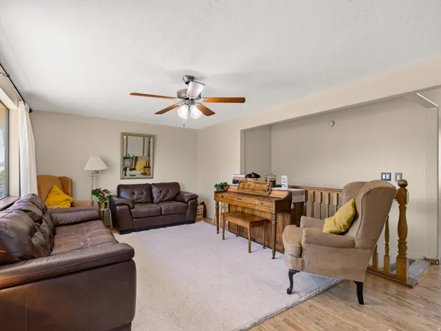 Living area featuring neutral wall tones, textured ceiling, and light wood-finish flooring