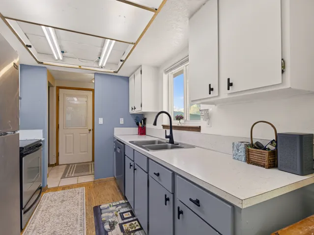 Kitchen featuring white upper cabinetry and gray lower cabinetry with matte black hardware