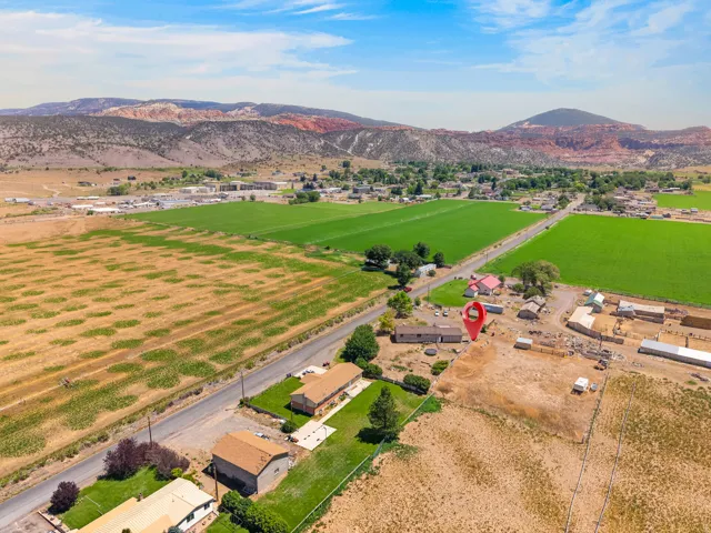 Expansive property featuring multiple structures, open land, and mountain backdrops