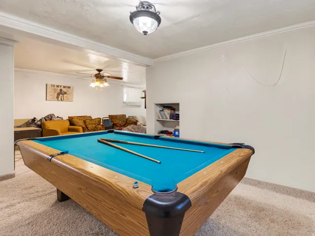 Recreation room featuring a built-in pool table with a wood-finish frame and teal felt