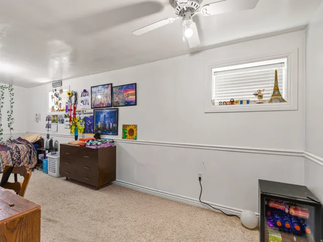 Recessed window with white blinds, neutral carpet flooring, and white wall paneling