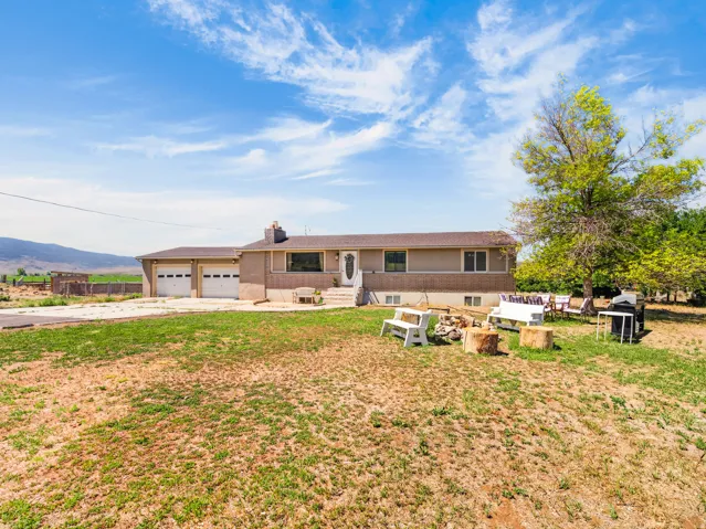 Ranch-style residence featuring a two-car garage, partial basement, and a prominent front entry with an exterior light fixture