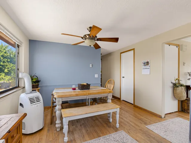 Interior space featuring wood-finish flooring, a window, and a ceiling fan with light fixture