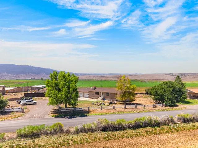Ranch-style residence featuring an attached two-car garage, mature landscaping, and a fenced perimeter