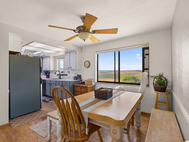 Dining area featuring wood-finish flooring and a ceiling fan with light fixture