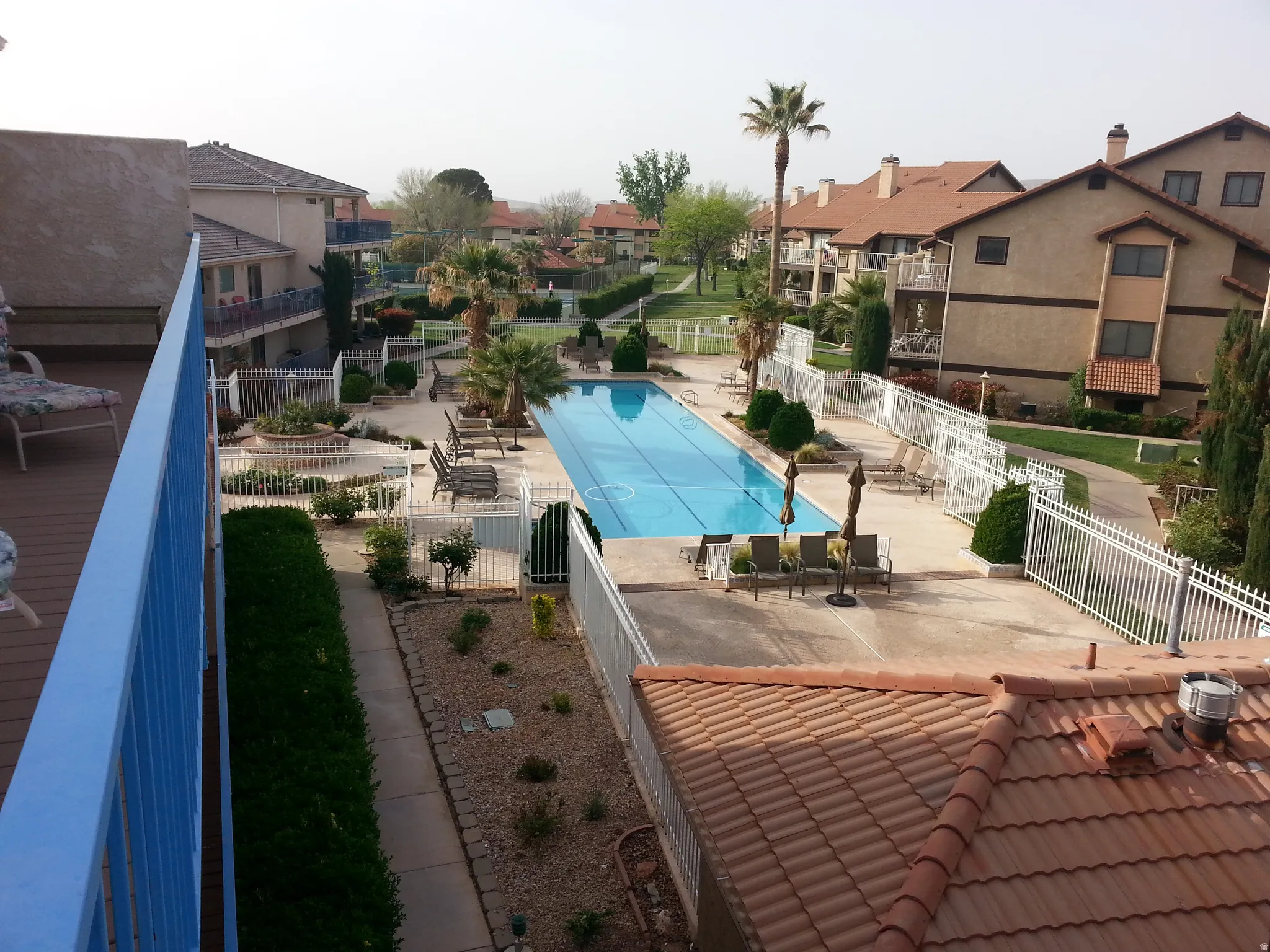 Expansive community Adult pool area featuring a rectangular pool, surrounding concrete deck, and perimeter fencing