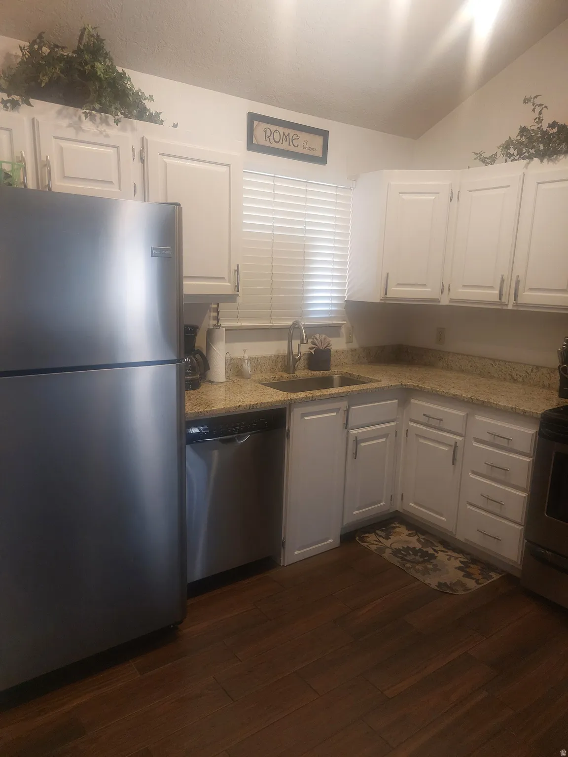 Kitchen featuring white cabinetry, granite-finish countertops, and wood-finish flooring