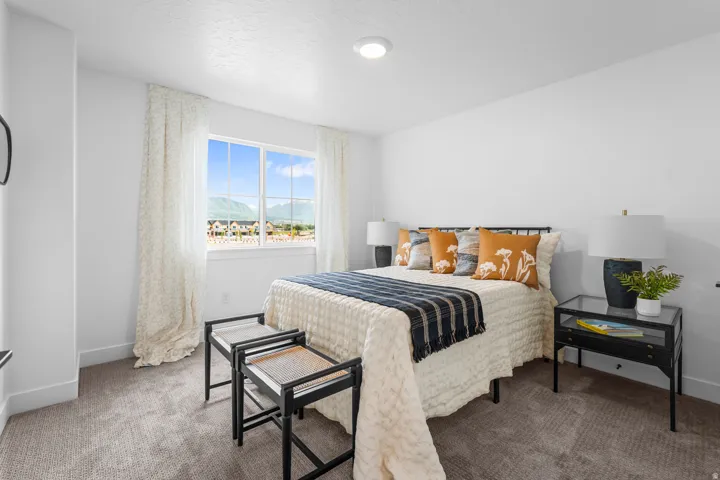 Bright bedroom featuring a large window with mountain scenery