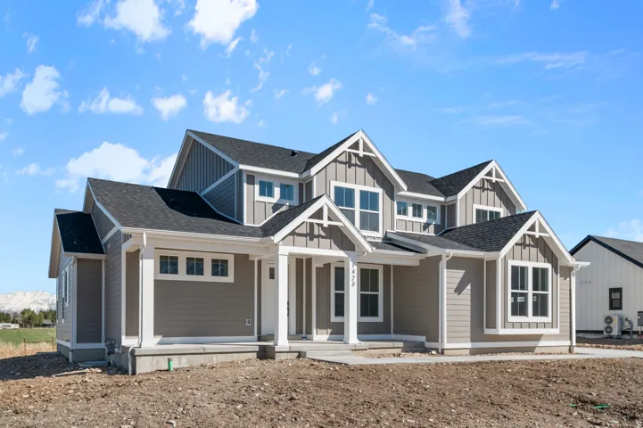Contemporary two-story residence with a gray siding exterior and dark shingle roof