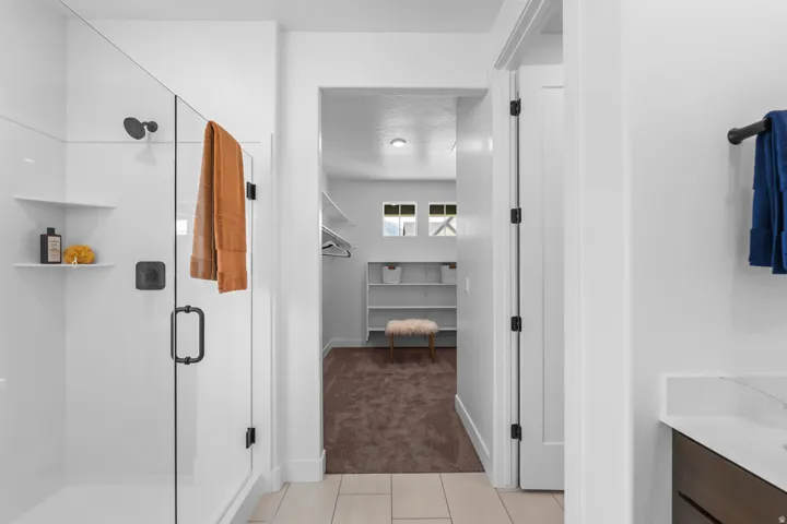 Walk-in shower with clear glass enclosure and matte black fixtures