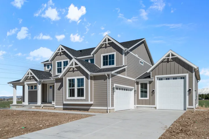 Craftsman-style exterior with board and batten siding, multiple gables, a covered entry porch, and a two-car garage