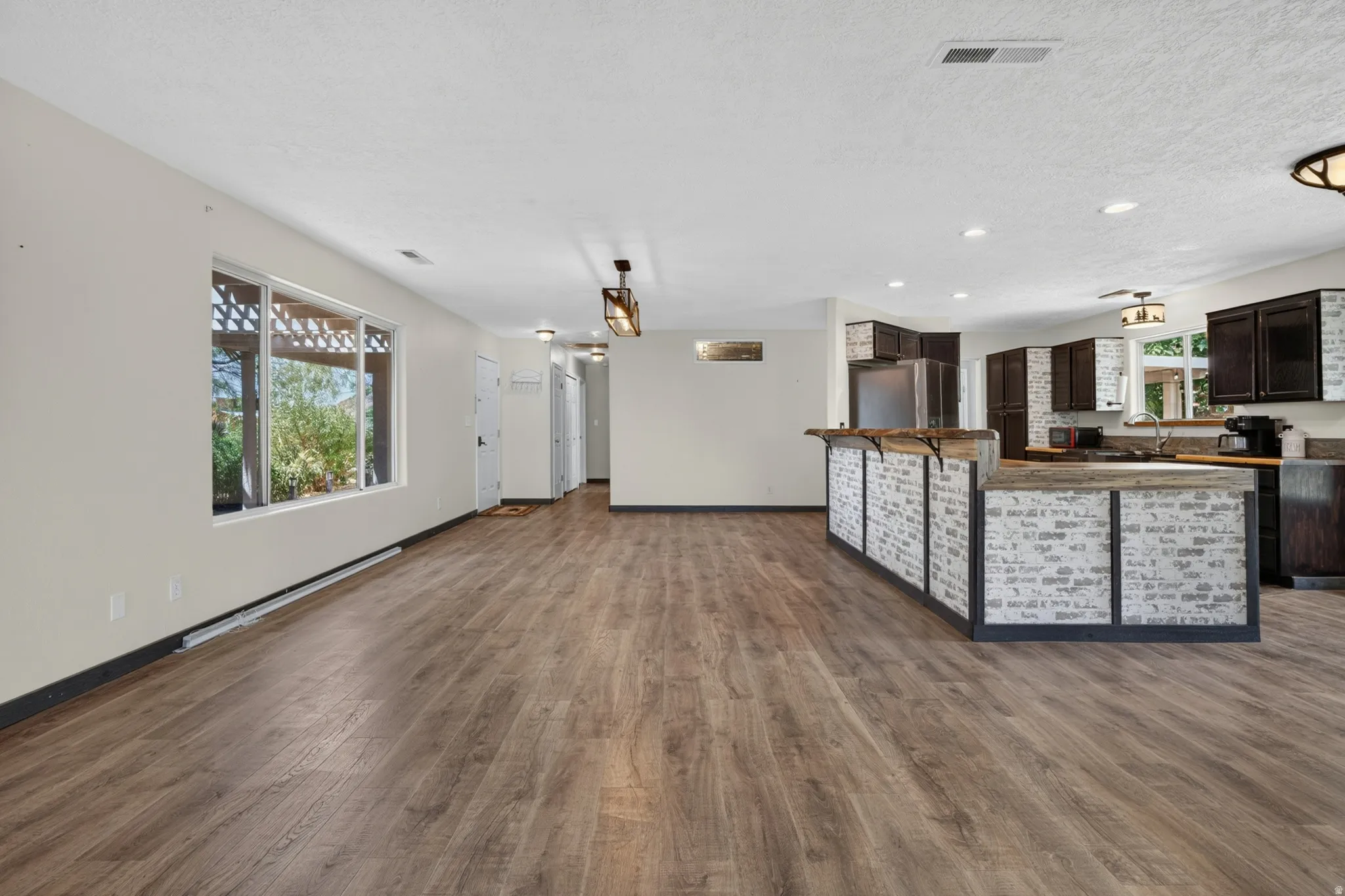 Spacious living area featuring wood-finish flooring, a large window, and recessed lighting