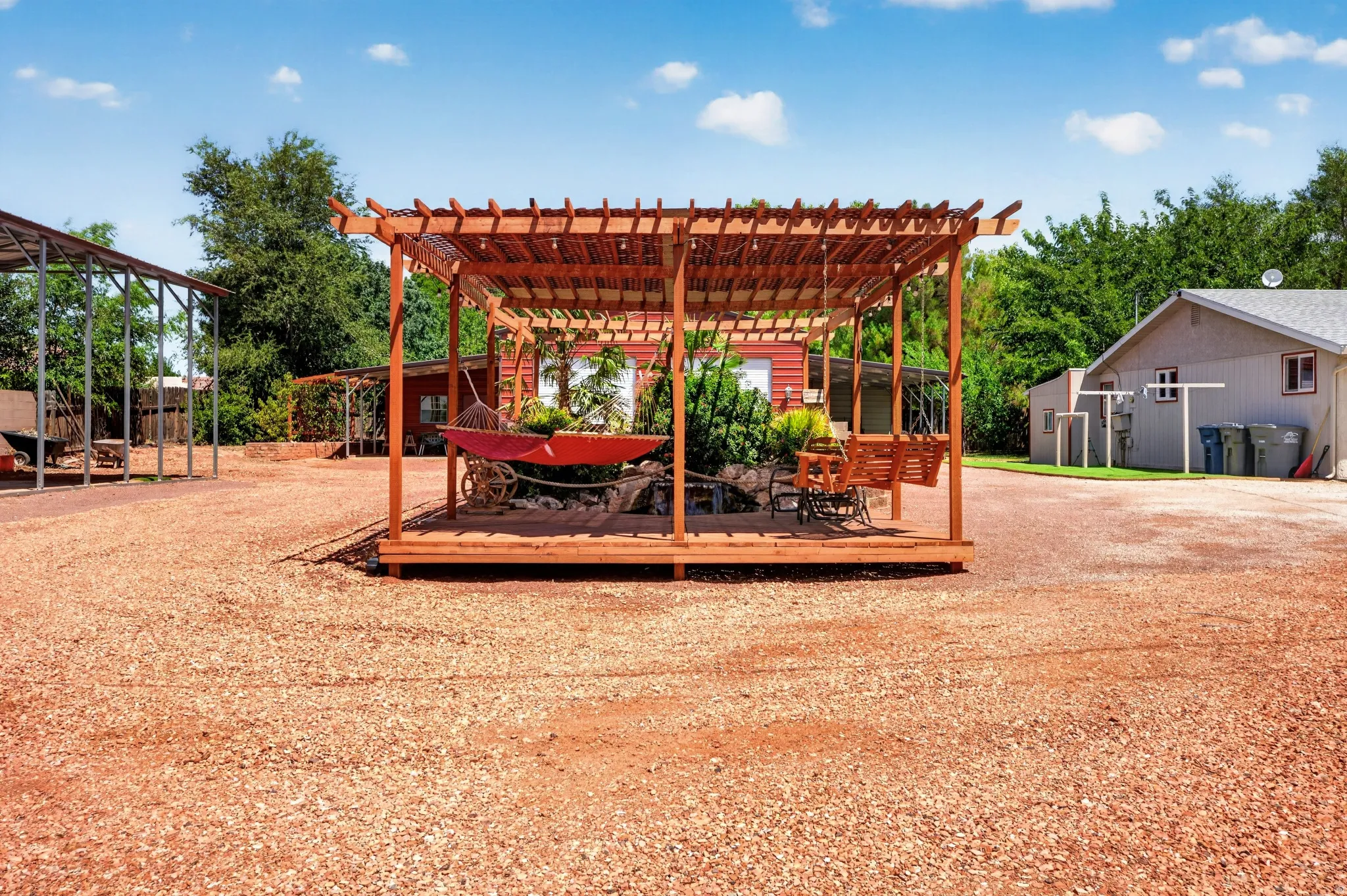 Wood pergola with a raised deck, featuring a swing bench