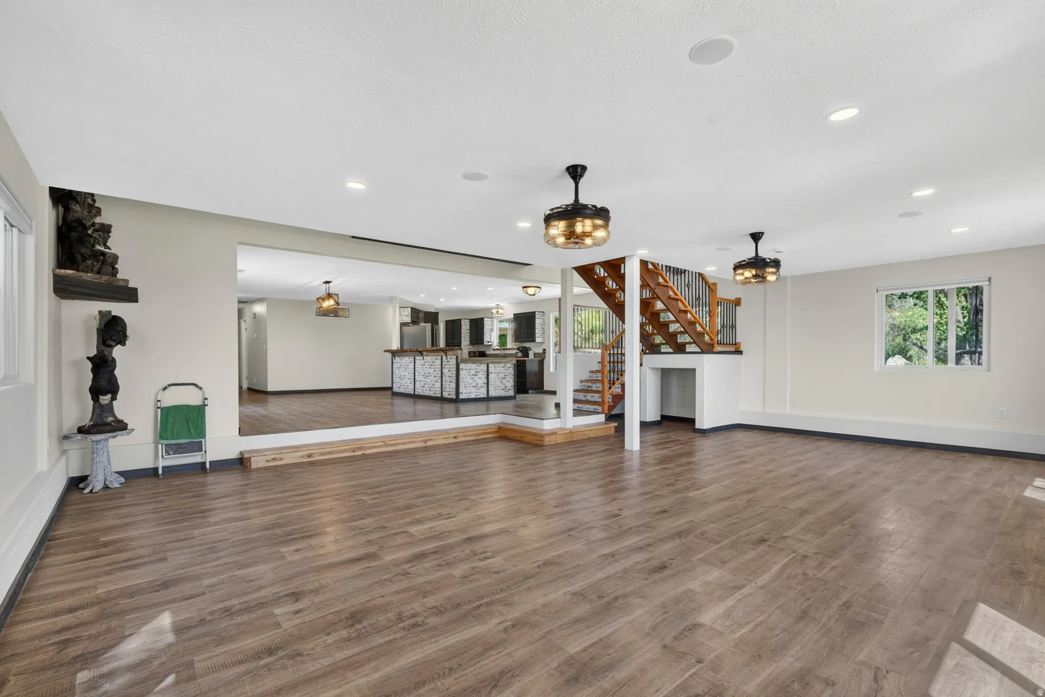 Expansive open-concept space featuring wood-finish flooring, recessed lighting, and modern ceiling fixtures