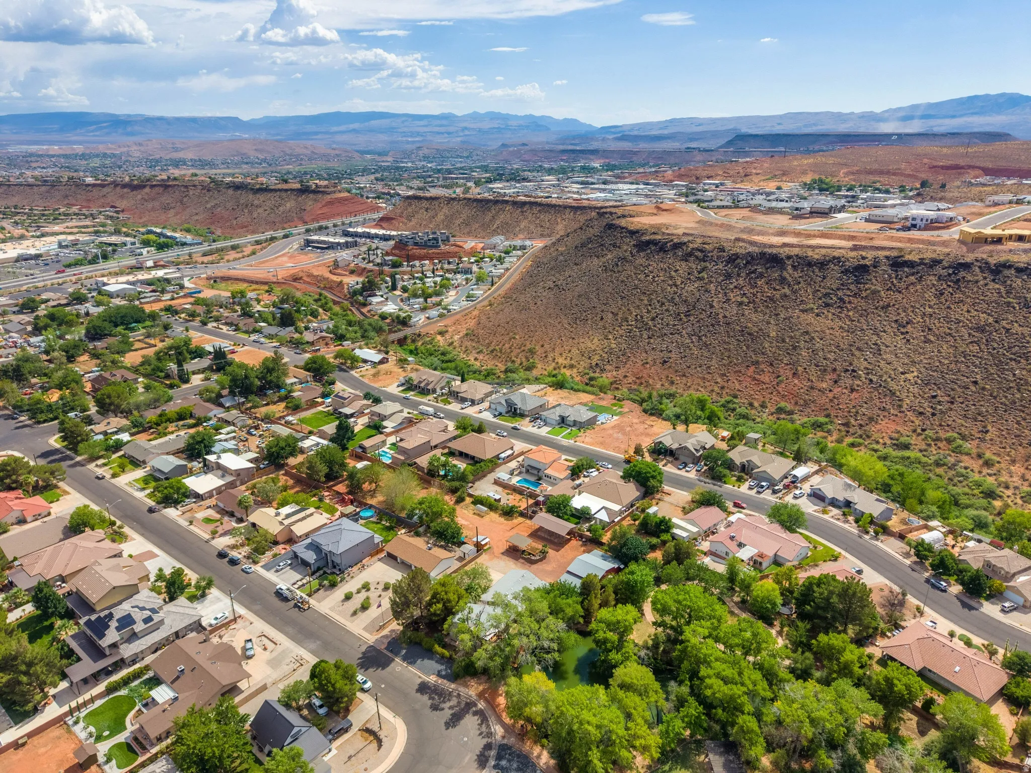 Aerial perspective showcasing a residential community against a backdrop of arid hills and distant mountains