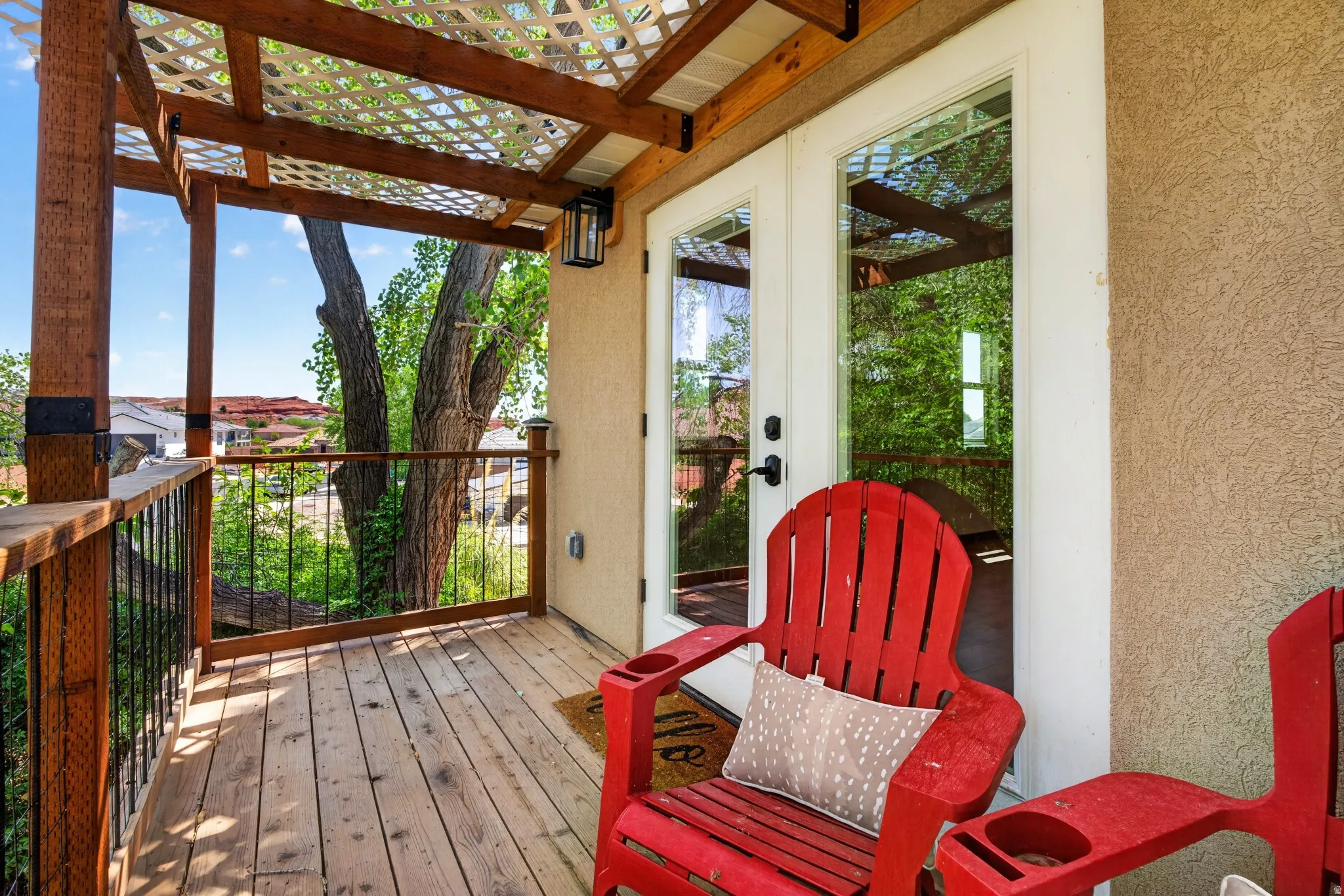 Wood deck with open lattice pergola and wrought iron railing