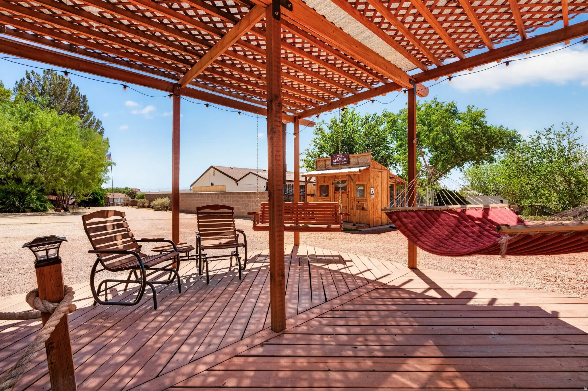 Expansive outdoor deck featuring wood-finish flooring and a slatted pergola