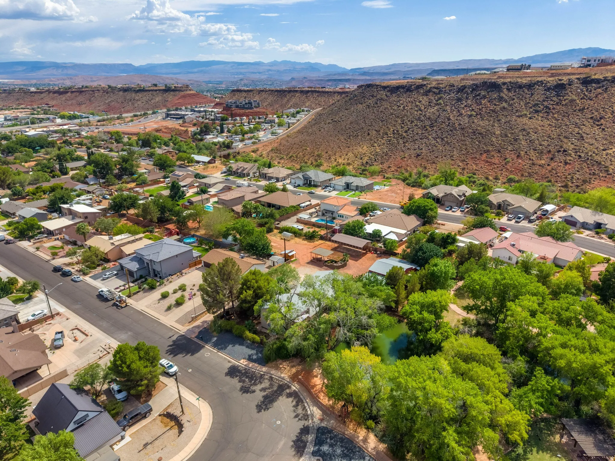 Residential neighborhood featuring established homes, mature trees, and a distant mountain backdrop