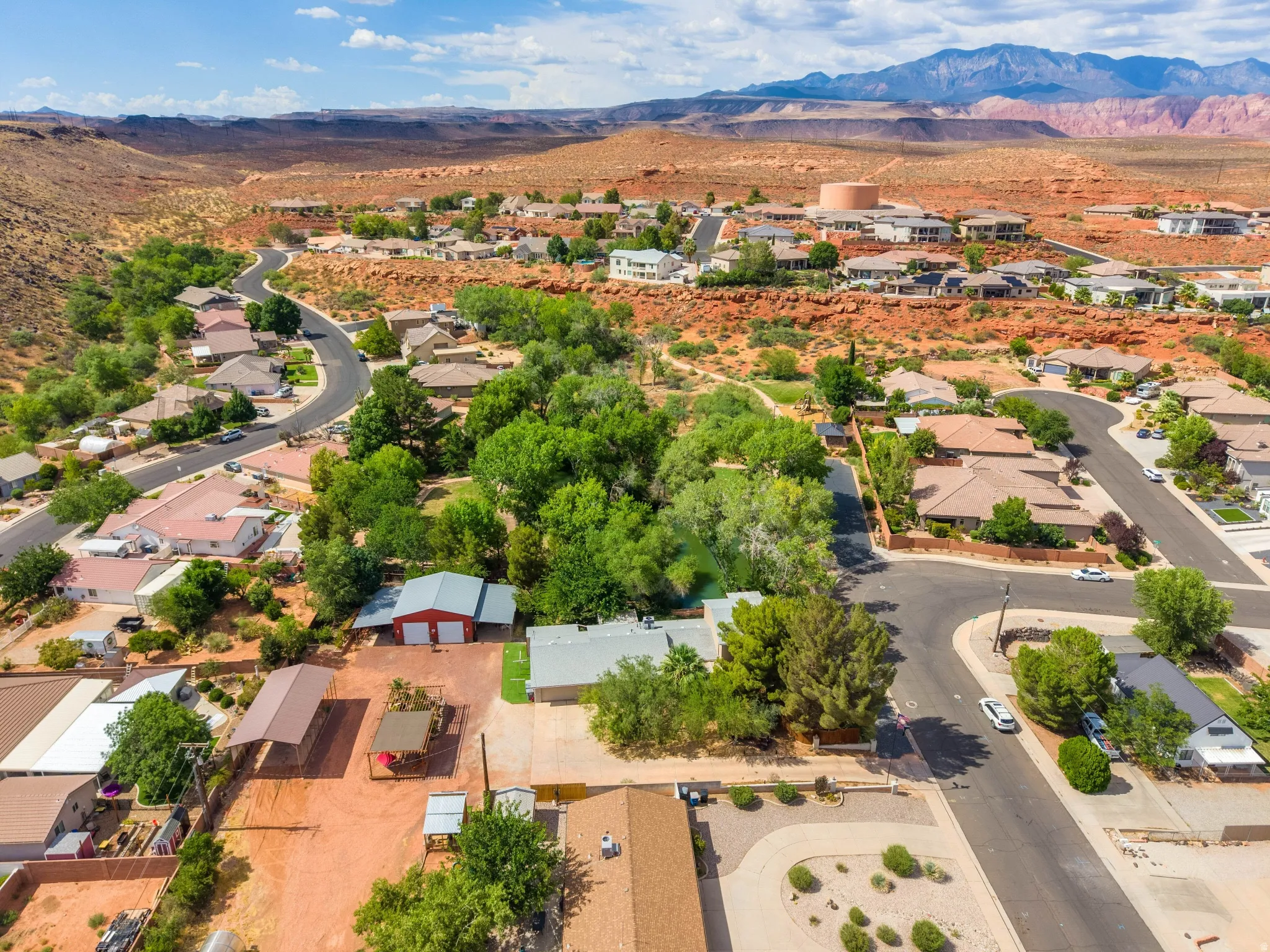 Residential neighborhood featuring mature trees and red rock landscape
