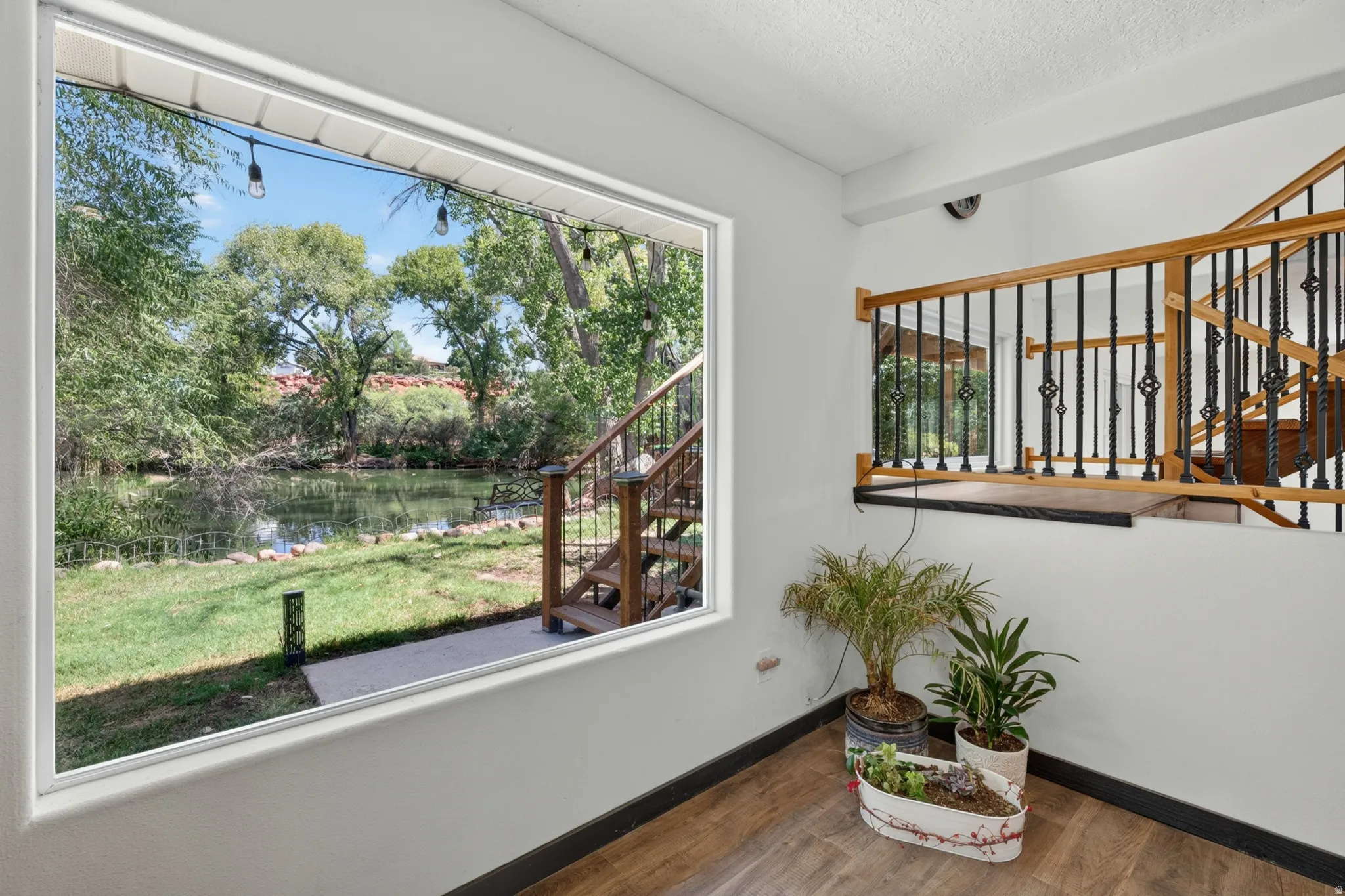 Expansive window offering clear views of a serene water feature and lush trees