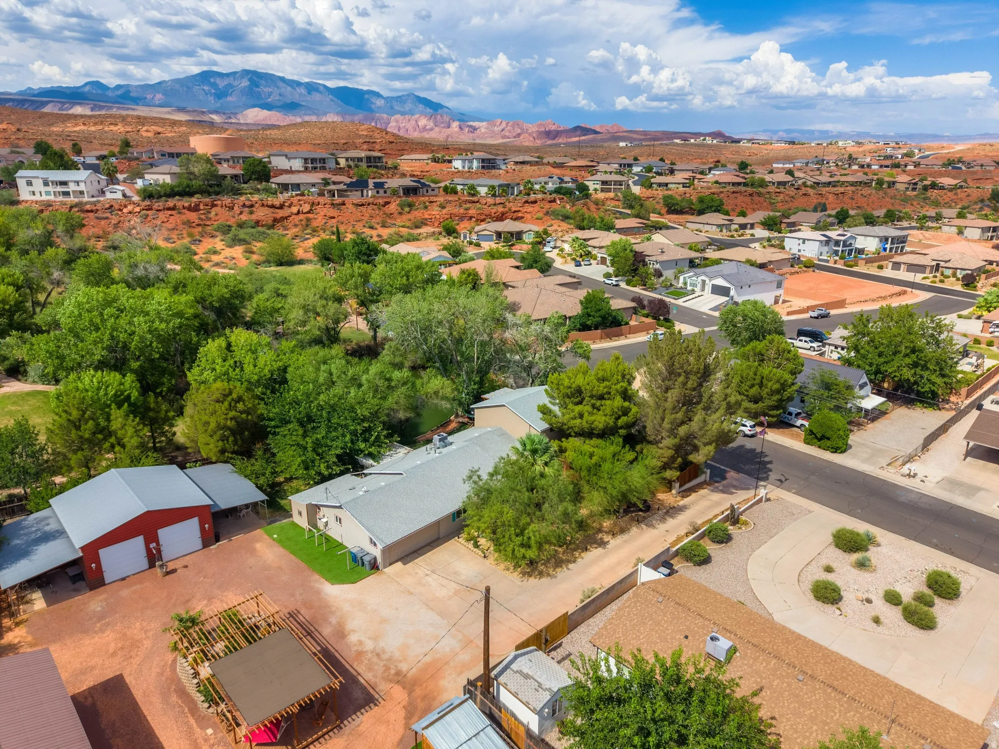 Aerial perspective highlighting a residential area with varied rooflines and surrounding red rock formations