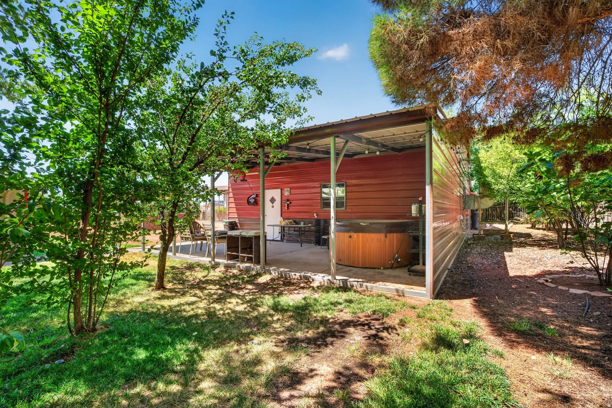 Red exterior structure featuring a covered patio with a built-in spa
