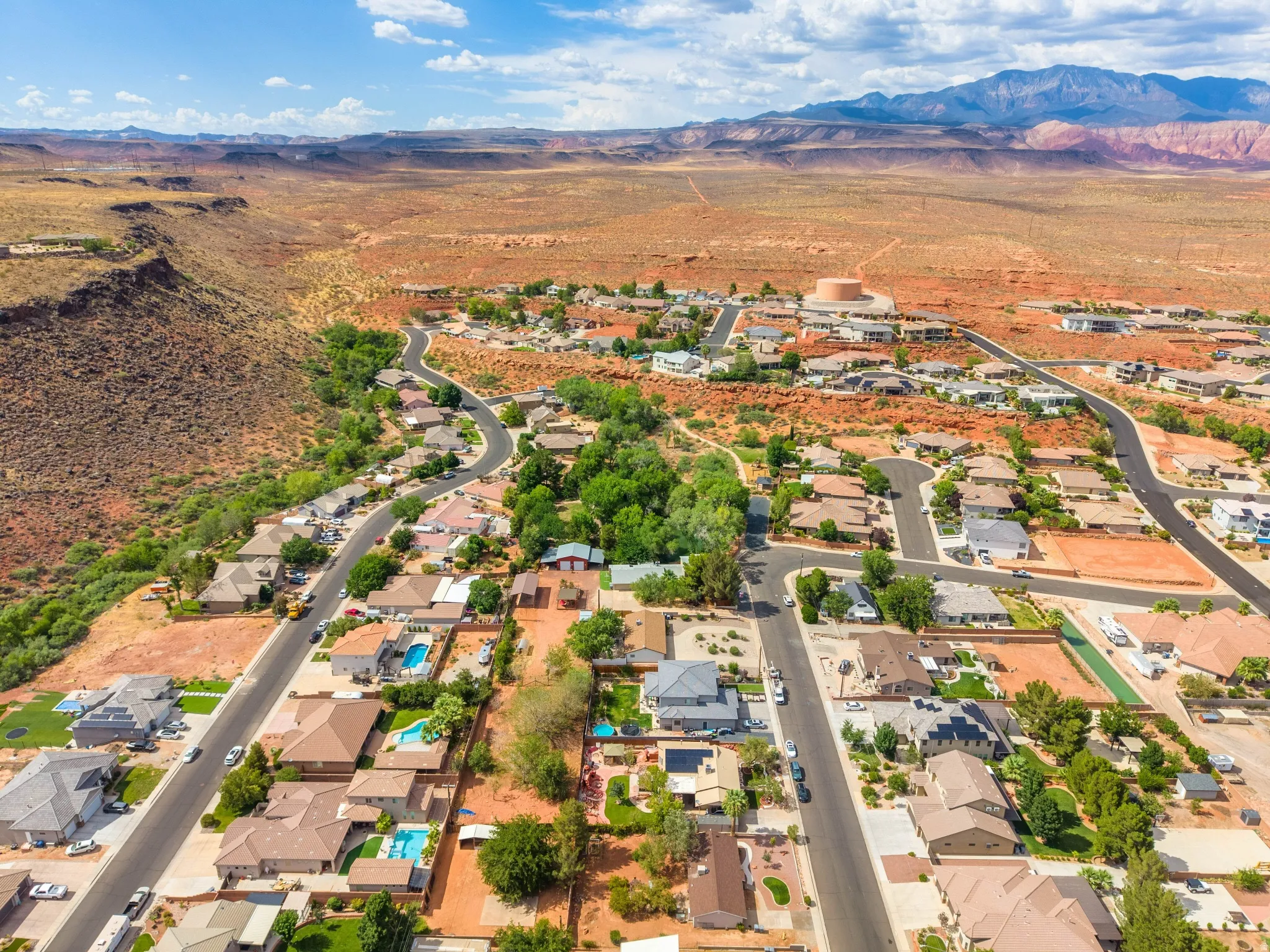 Aerial perspective showcasing a residential community with mature trees and a desert landscape backdrop