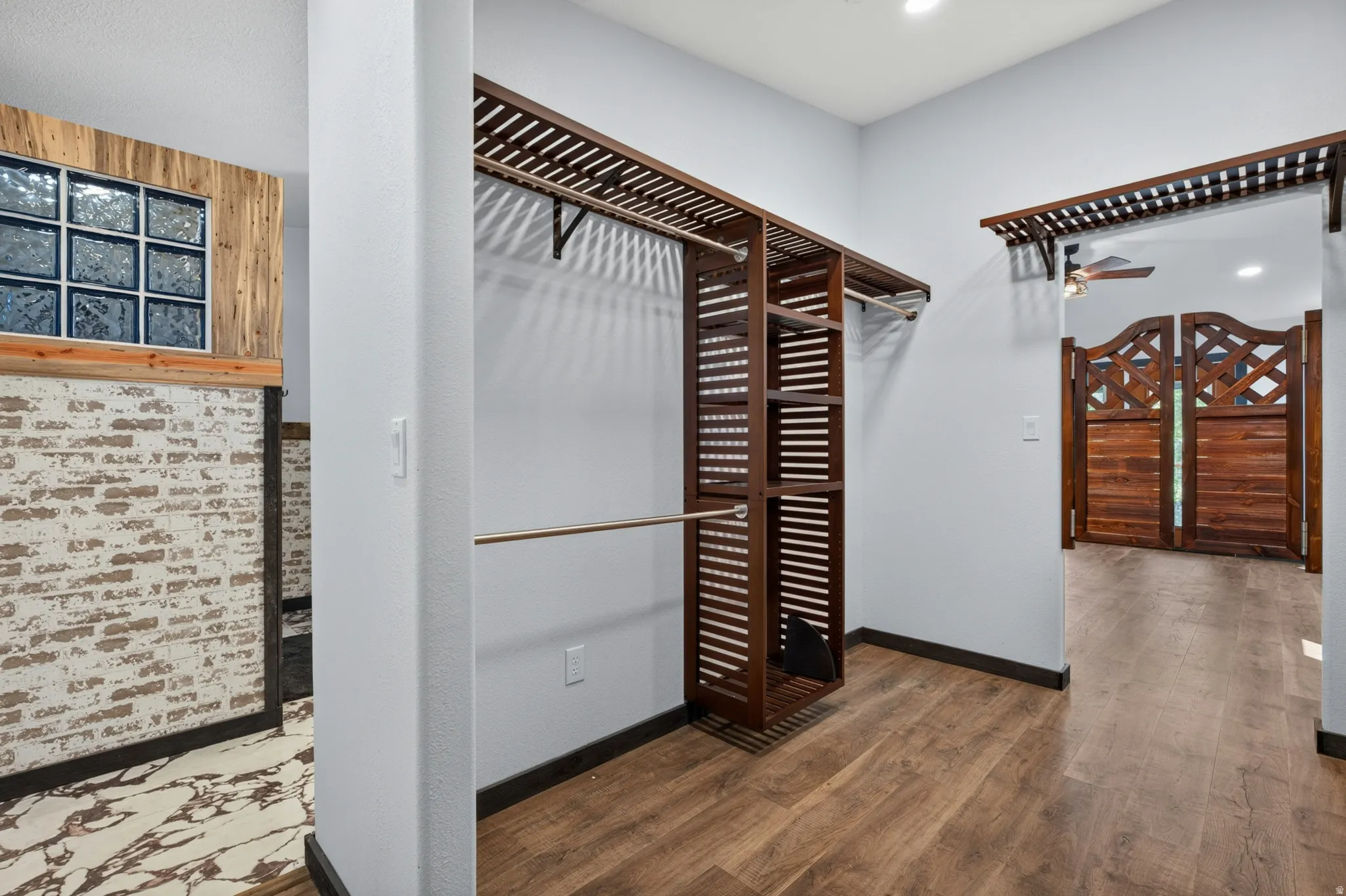 Custom closet system featuring dark wood-finish shelving and hanging rods