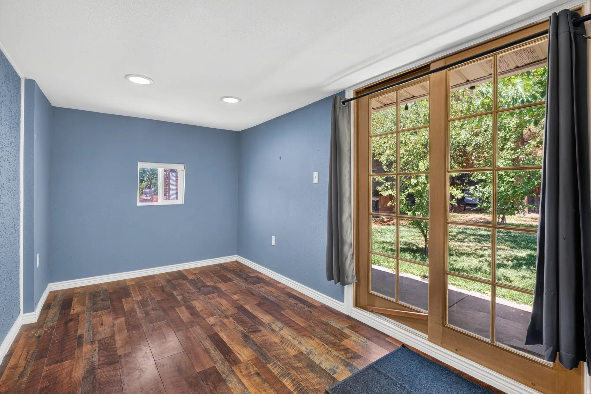 Interior room featuring wood-finish flooring, recessed ceiling lighting, and blue painted walls