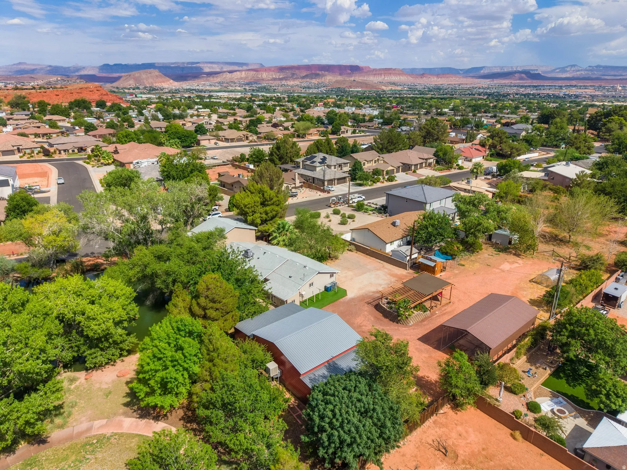 Aerial perspective showcasing multiple properties amidst mature trees and arid landscaping