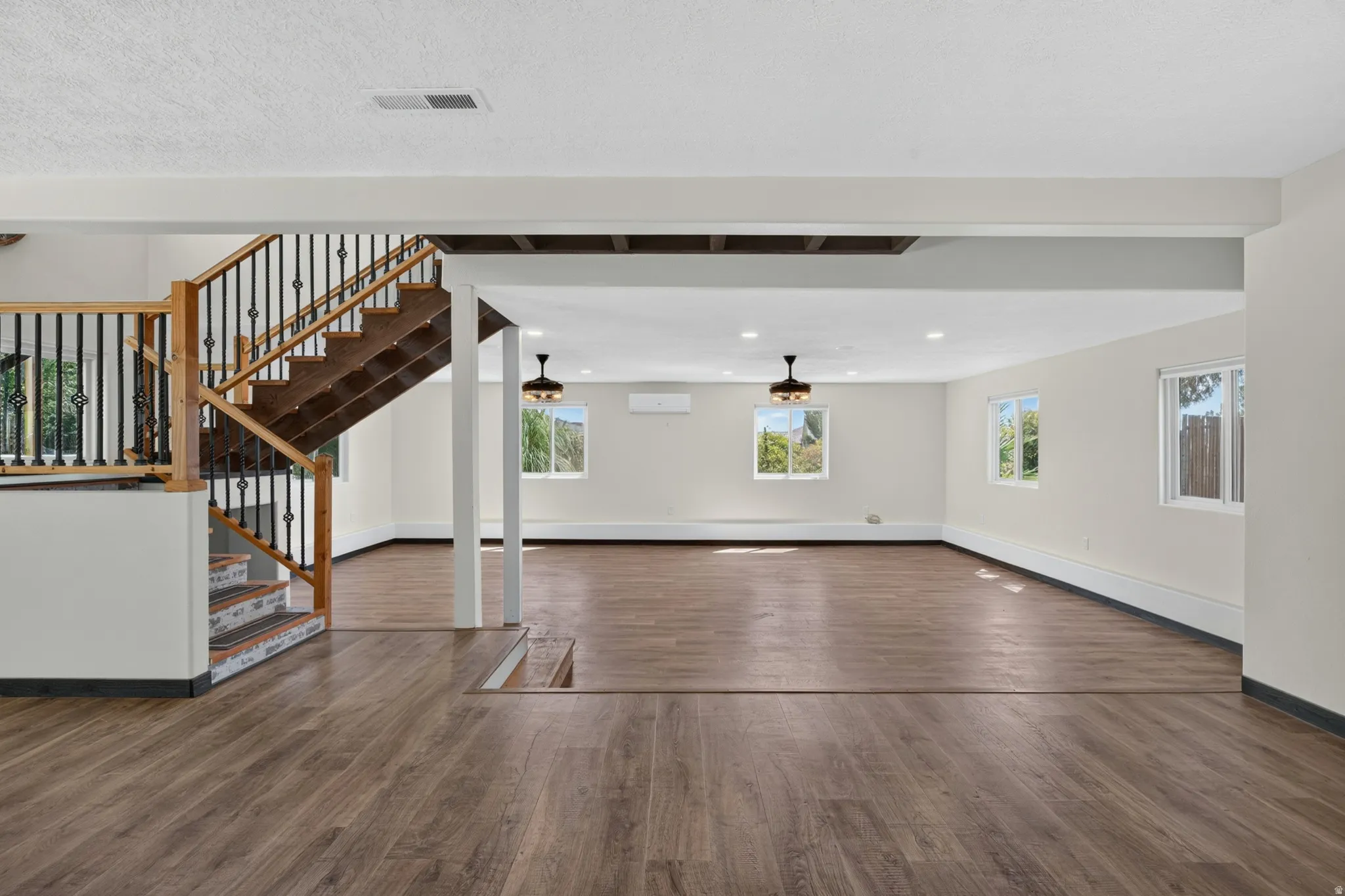 Open lower-level space featuring wood-finish flooring throughout