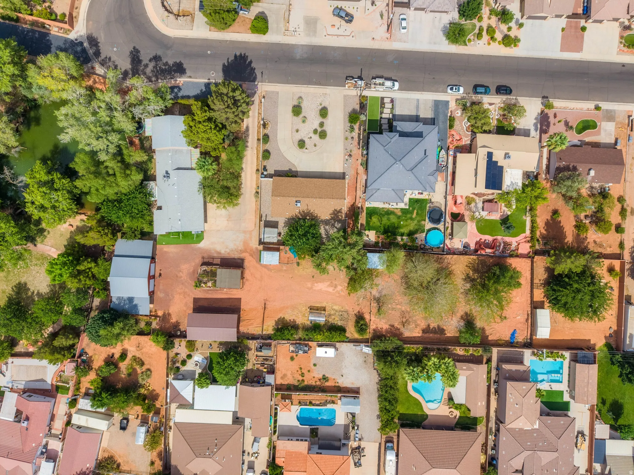 Aerial perspective showcasing a residential property with a dark-tiled roof and a light-colored driveway
