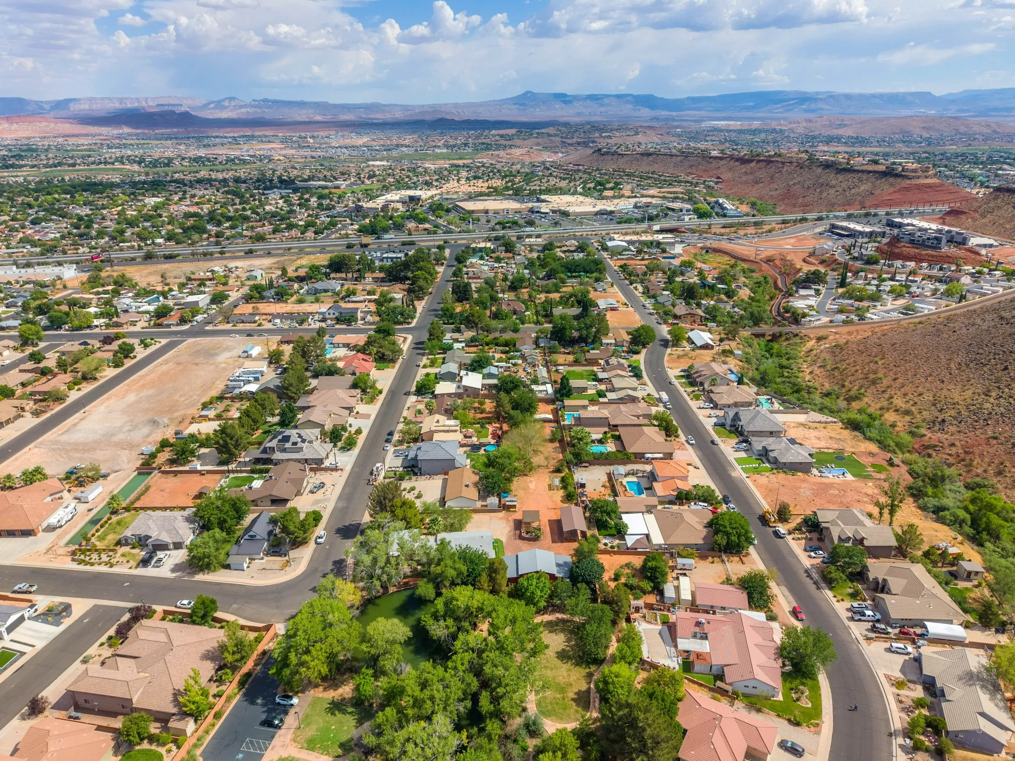 Aerial perspective showcasing a residential area with varied housing styles, mature landscaping, and paved roads