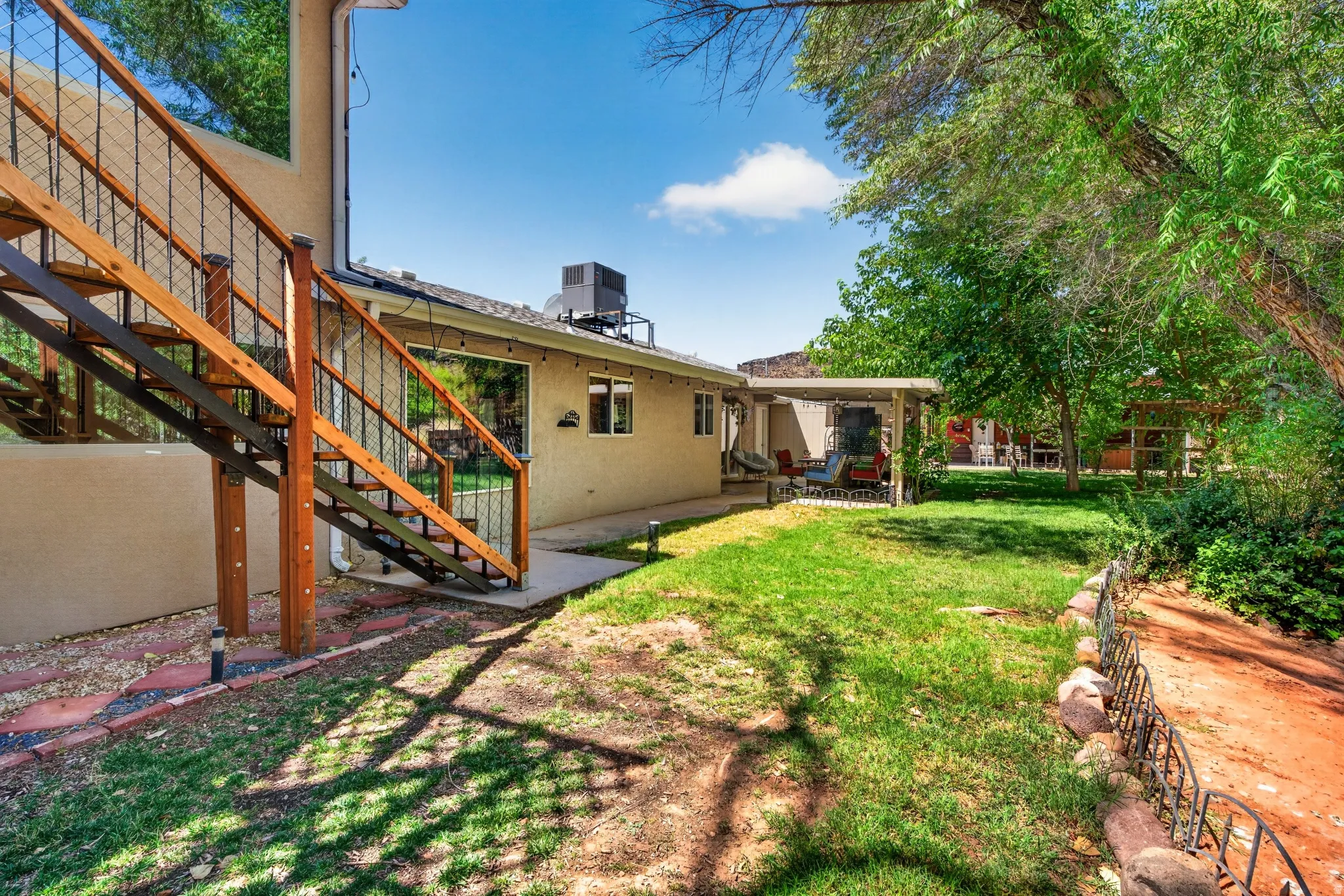 Expansive backyard featuring a manicured lawn and mature trees