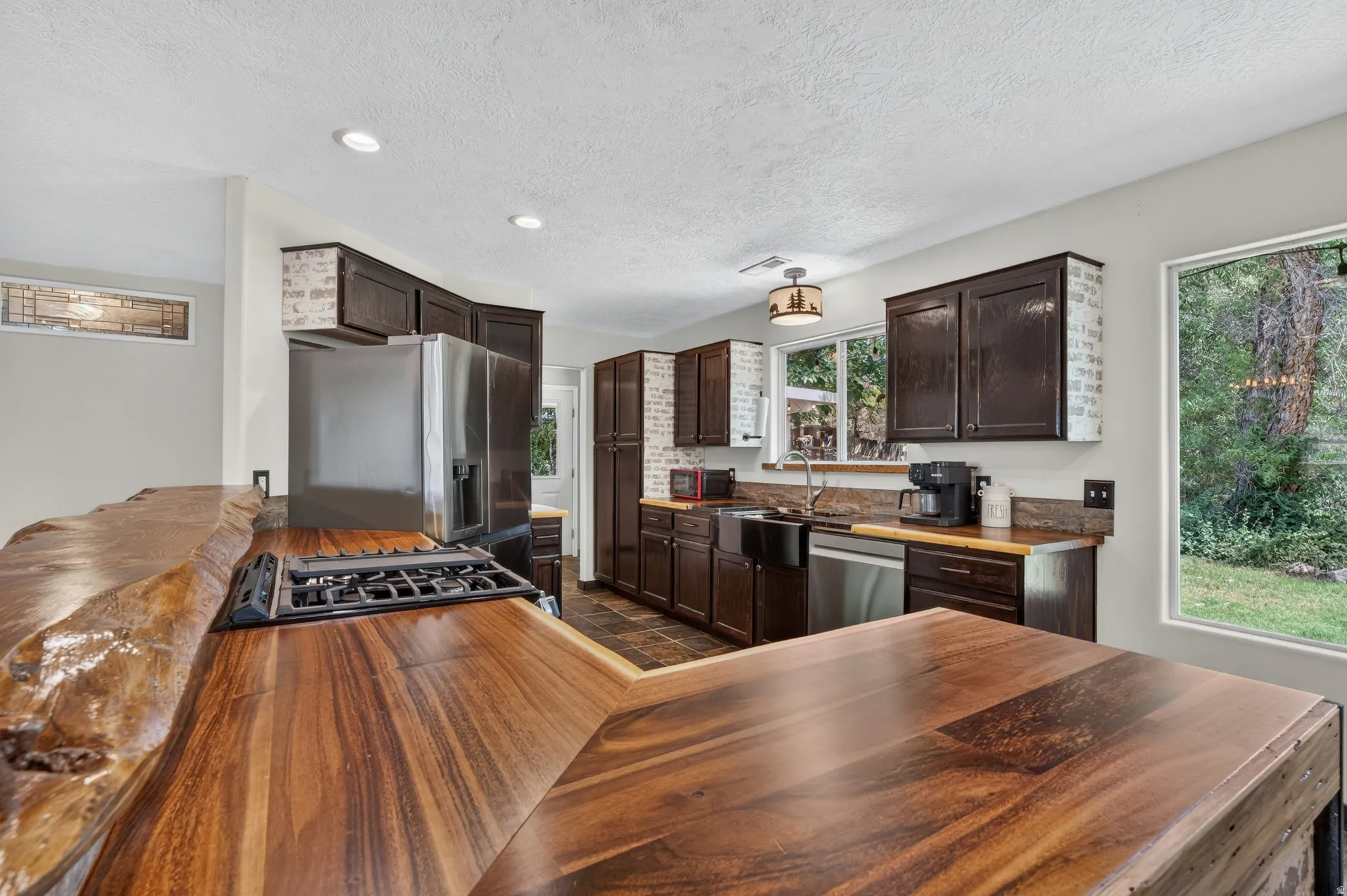 Live-edge wood-finish countertop with an integrated gas cooktop