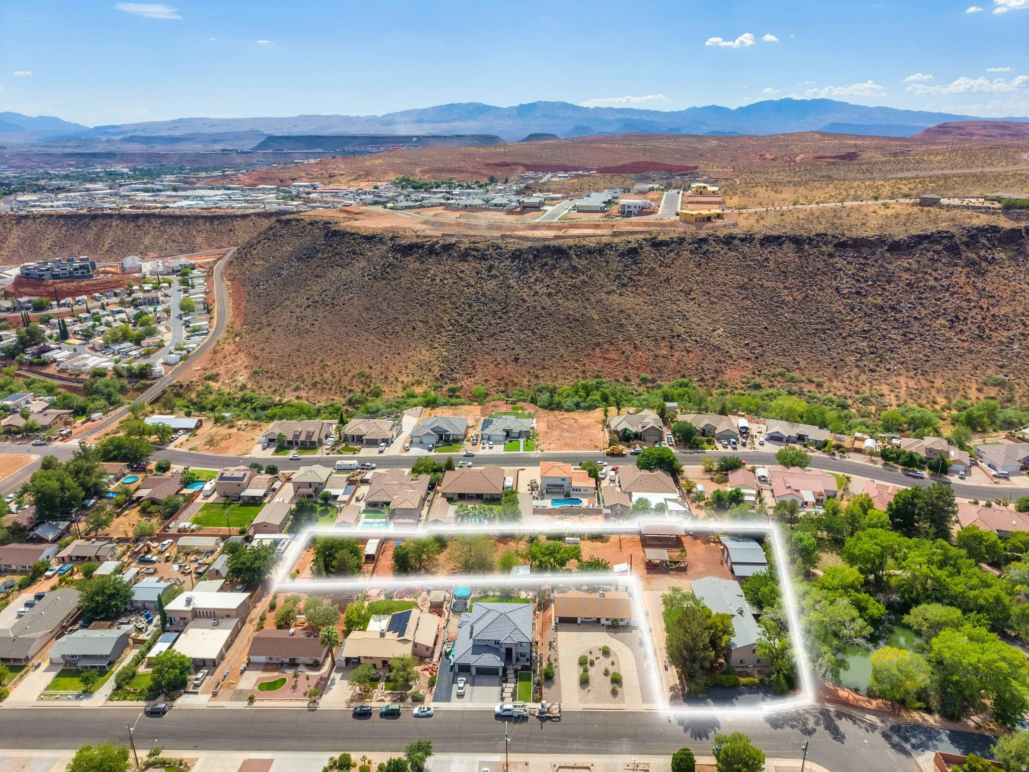 Aerial perspective showcasing a residential area with a prominent red rock mountain backdrop